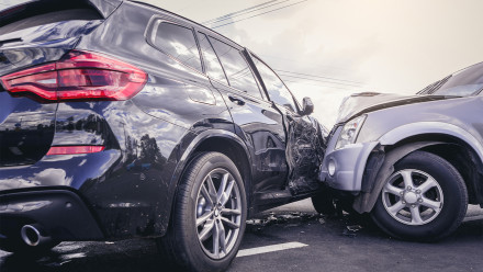 Severe side-impact collision between black SUV and silver car showing major vehicle damage from motor vehicle accident