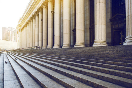Wide stone steps and colonnaded facade of courthouse exterior representing access to criminal defense justice