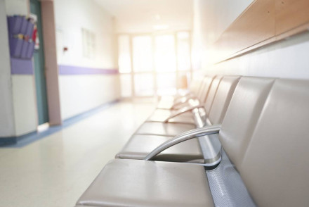 Empty hospital waiting room chairs in corridor representing delayed medical care and negligence