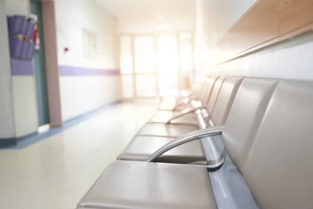 Empty hospital waiting room chairs in corridor representing delayed medical care and negligence