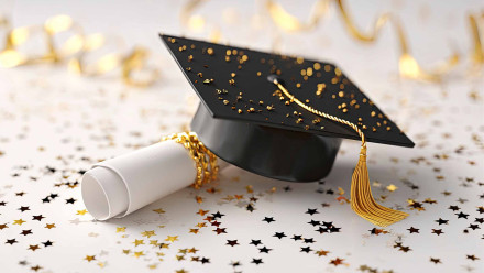 Graduation cap and diploma with gold confetti celebrating Gideon Asen law firm scholarship recipient